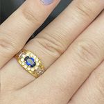 Anel de formatura em ouro 18 k com 2.5 gramas com 12 pedras com uma pedra oval safira sintética com dois símbolos em ouro branco