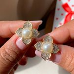 Brinco de flor trabalhada com perola no centro 