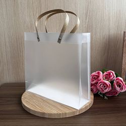 Sacola de Plástico PVC Leitosa C/Alça Kraft - 26X2... - CHAMMA FESTA