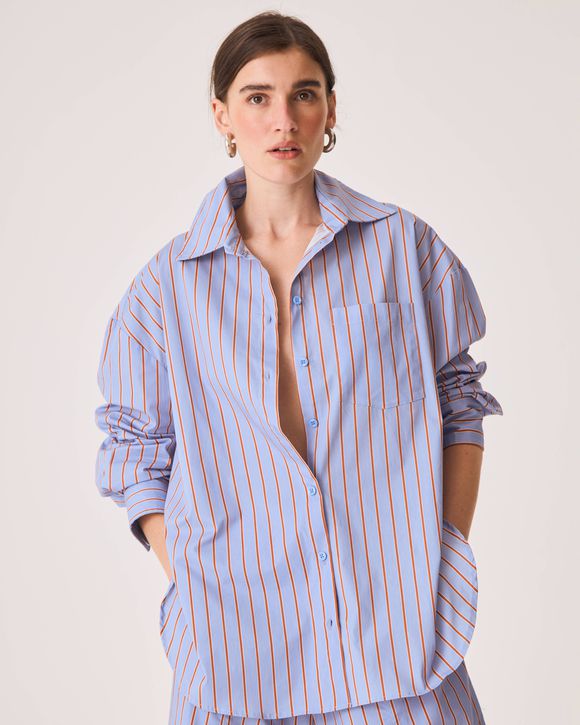 Camisa feminina oversized azul listrada com mangas longas, gola tradicional e bolso lateral