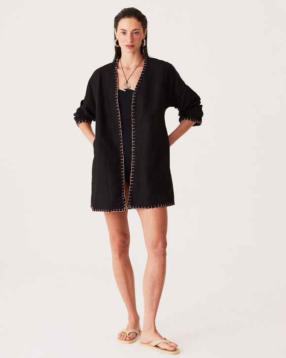 Modelo veste roupão de linho preto bordado, exclusivo Ava com modelagem sofisticada e tecido leve.