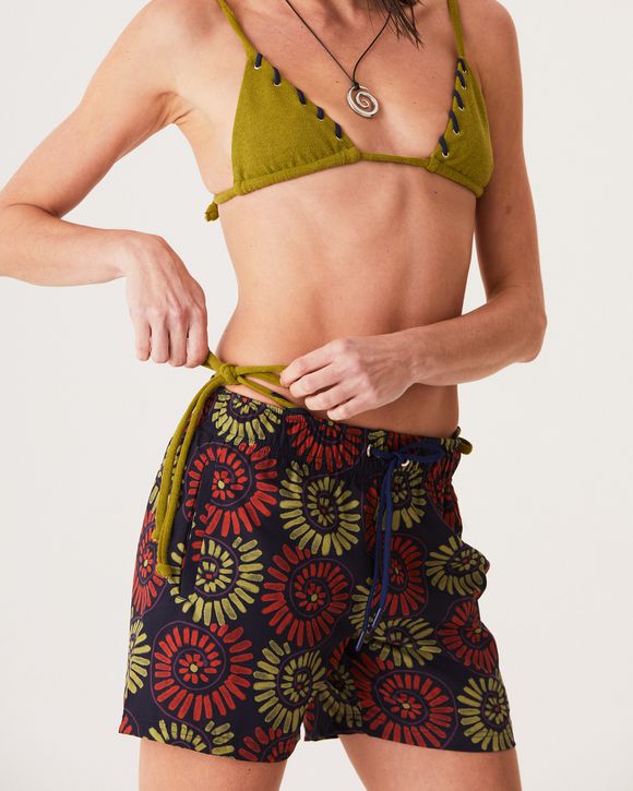A Modelo esta vestindo um Short com estampa de conchas, modelagem clássica e tecido leve, ideal para o verão e momentos casuais.