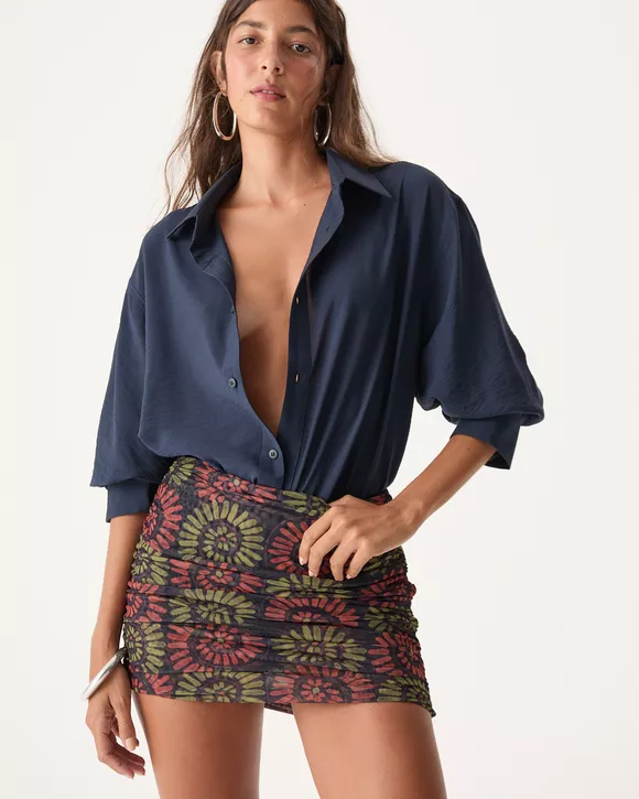 Modelo feminina veste Camisa Azul Noite Bia com botões personalizados e caimento elegante.