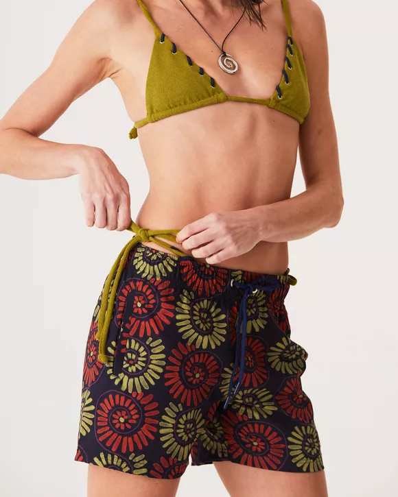 A Modelo esta vestindo um Short com estampa de conchas, modelagem clássica e tecido leve, ideal para o verão e momentos casuais.