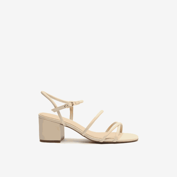 Sandália Off-white. O modelo tem salto médio bloco e bico redondo. Traz tiras finas bombadas cruzadas sobre os dedos, no peito do pé e cruzadas também no tornozelo, fechando em fivela lateral. A sandália é aberta e exibe dedos e calcanhar
