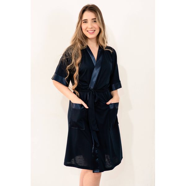 Robe trespassado em tecido de PV (65% poliéster e 35% viscose) com detalhes em cetim e dois bolsos funcionais. Na cor azul marinho.