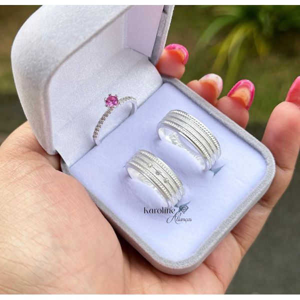 Alianças Ravena com 7 mm com 3 pedras de zirconia com detalhes recartilhados com solitario princesa cor rosa 