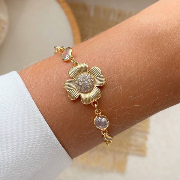 Pulseira com um pingente de flor e pedras de zircônia.