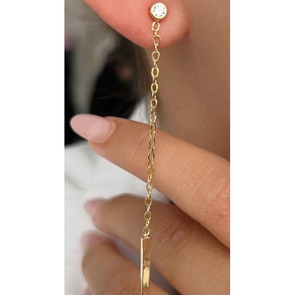 Brinco pendente dourado com um ponto de luz e um pingente de barra