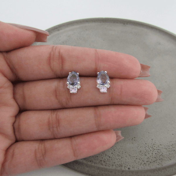 BRINCO GOTA GALERIA DE ZIRCÔNIA NA COR LILÁS COM 2 ZIRCÔNIAS PEQUENAS NO CRISTAL E 1 ZIRCÔNIA NA COR ROSA
