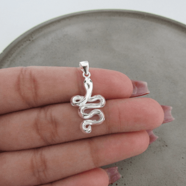 PINGENTE SERPENTE ENROLADA LISA COM OLHOS DE ZIRCÔNIA NA COR ESMERALDA 25MM